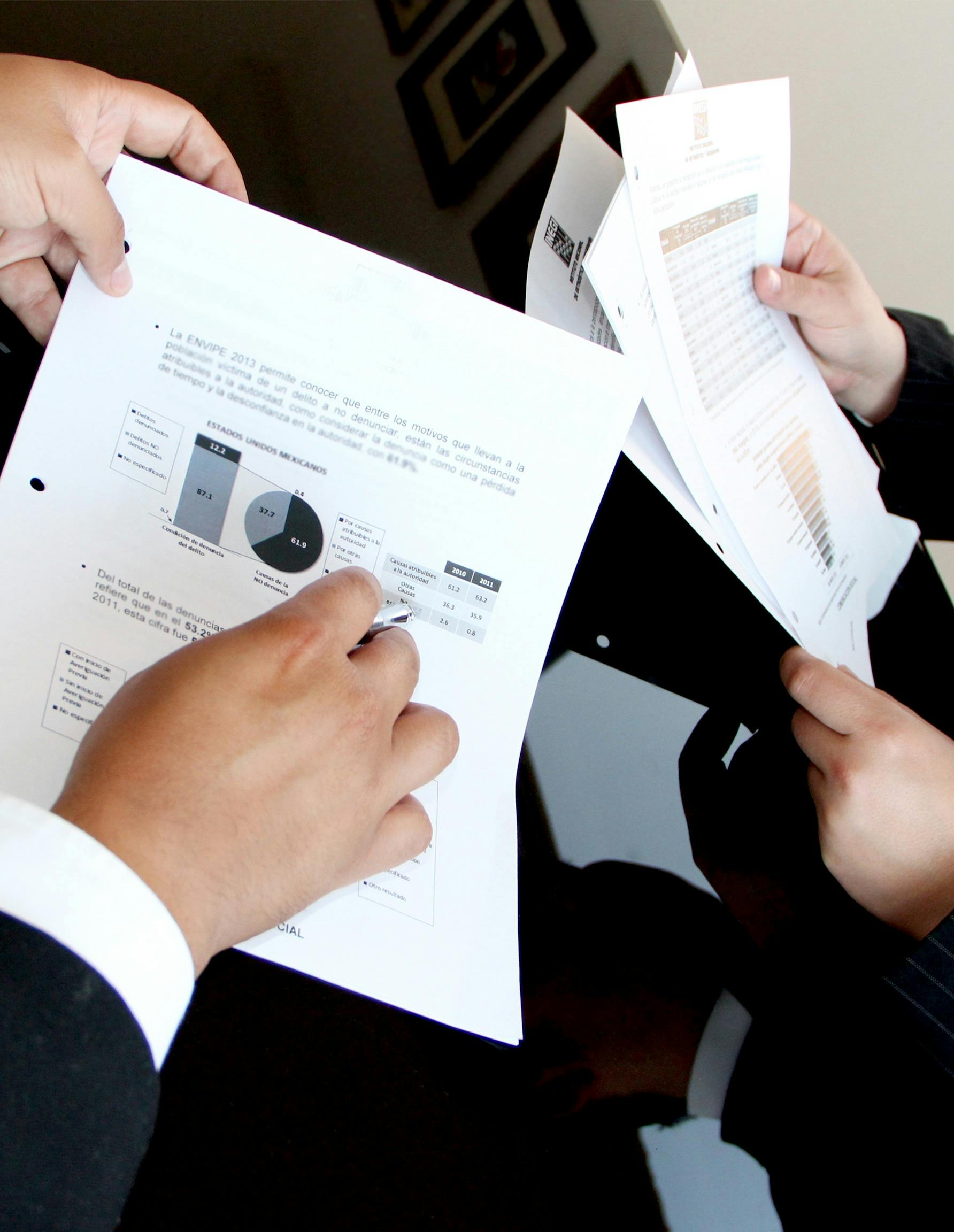 Picture of business men hands pointing at peace of paper that has data analytics, used for general corporate thumbnail